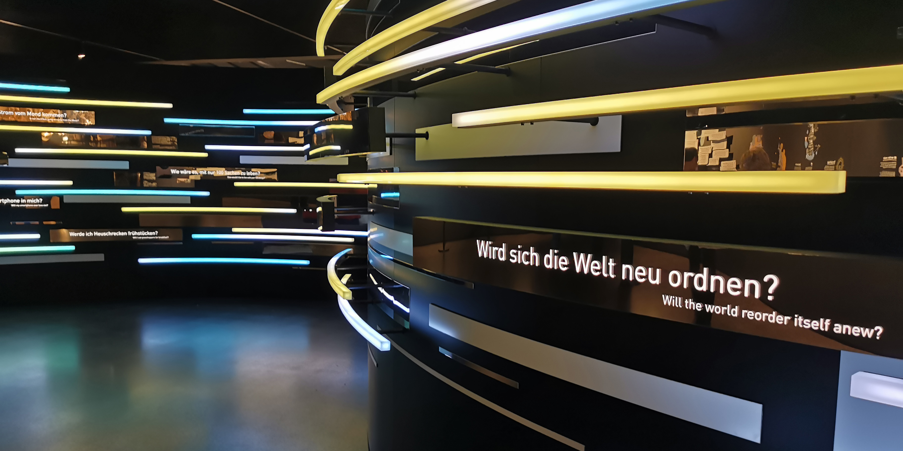 Foto einer Wandinstallation mit Licht und der Frage "Wird sich die Welt neu Ordnen" im Futurium